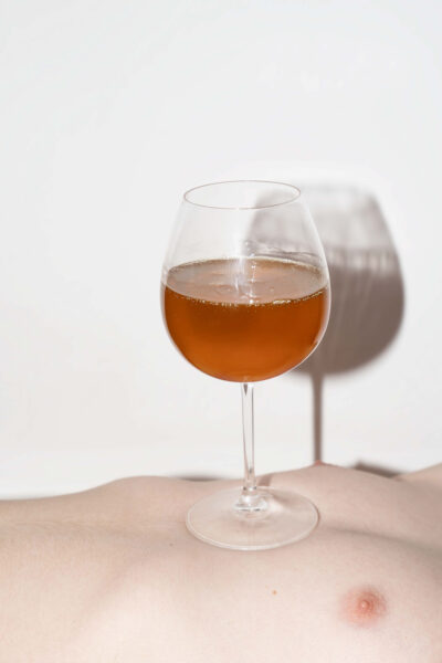 Weinglas mit Honig auf nacktem Körper