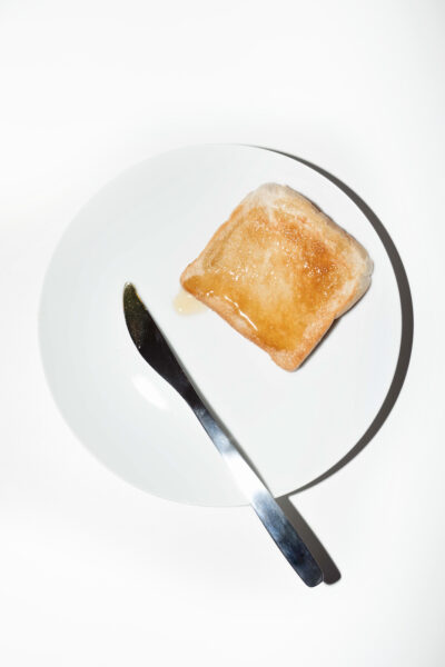 Honig-Toast und Messer auf weißem Teller