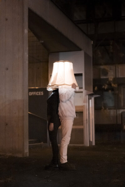 zwei Personen, Köpfe unter einem leuchtenden Lampenschirm