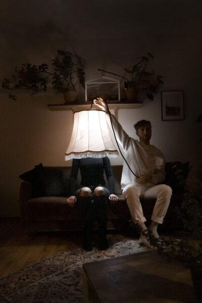 zwei Personen auf Sofa mit leuchtendem Lampenschirm